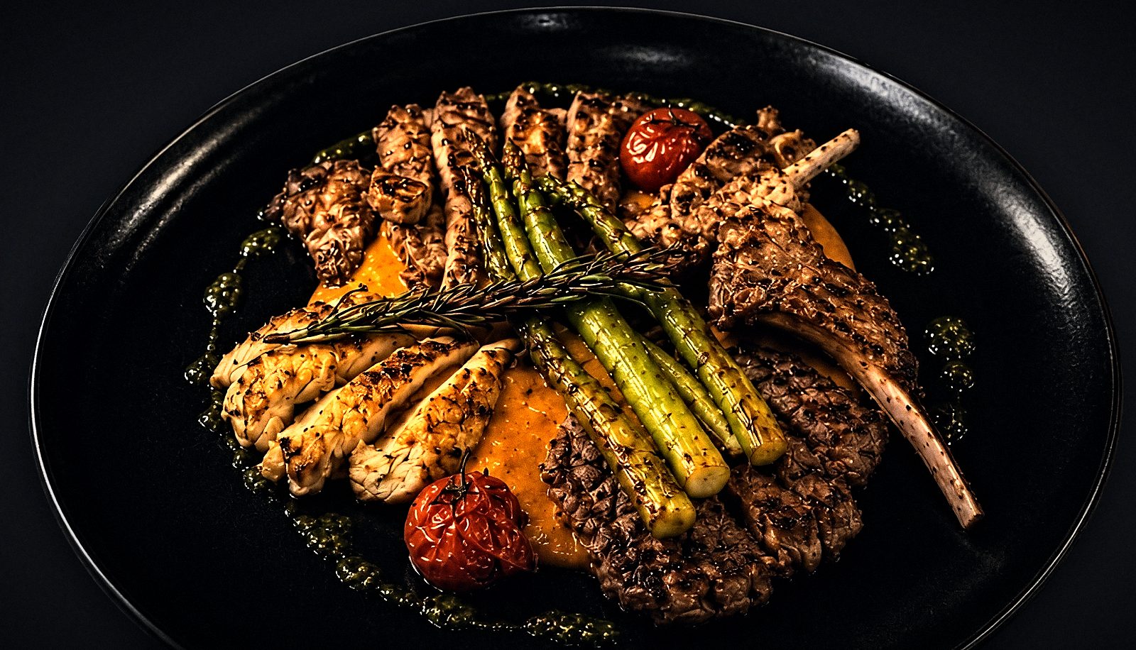 La Foresta Terra: gegrillte Fleischplatte mit Lammkoteletts, Hähnchenbrust, grünem Spargel und Terra-Sauce